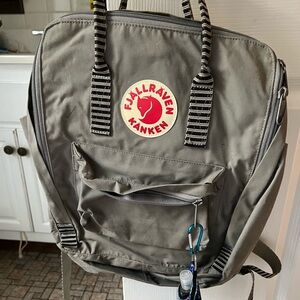 Grey regular size Kanken backpack with black & grey striped straps